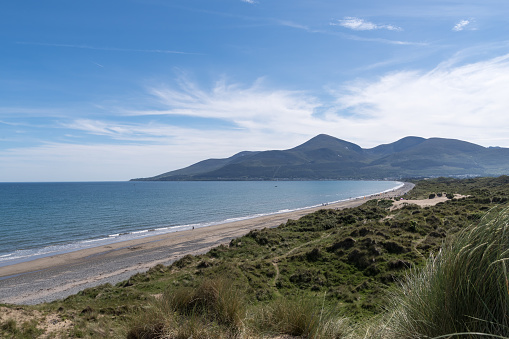 Coastal dunes, beach shoreline, receding tide and the outline of the Mountains of Mourne at Newcastle, County Down, Northern Ireland.