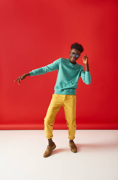 istock Positive guy in glasses is dancing on red background 1157803221