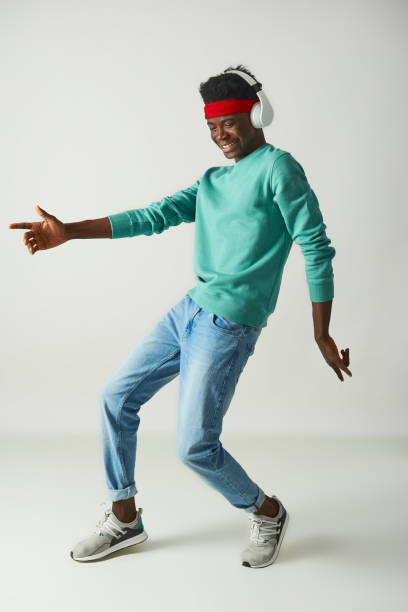 istock Positive young guy with red bandage is dancing in studio 1157803336