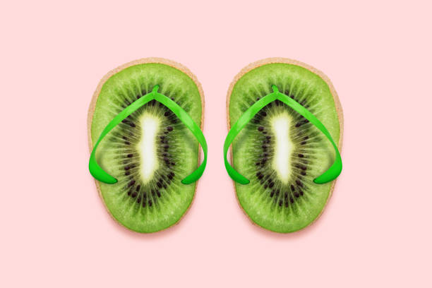 Kiwi Flip flops on pastel pink background Summer concept flat lay minimal