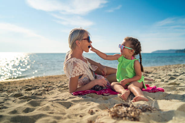istock Girl feeding her mother on the beach 1157804313