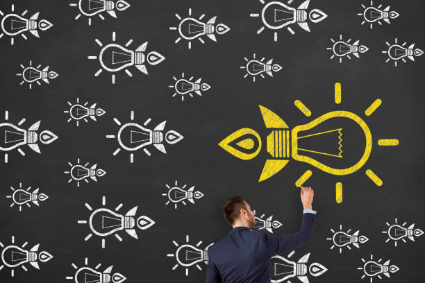 istock Going Your Own Way with Light Bulb on Blackboard Background 1157804484