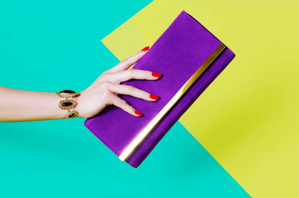 Woman's hand holding purple purse beautiful red manicure nails and vintage bracelet. fingernail photos stock pictures, royalty-free photos & images