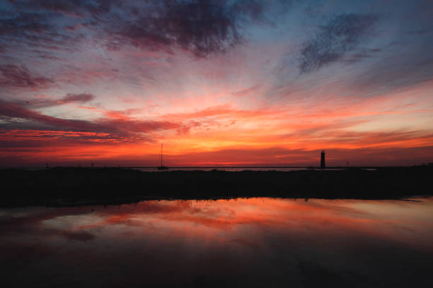 Sunset reflection with lighthouse over lake stock photo