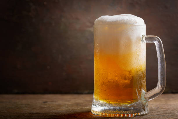 istock mug of beer on a wooden table 1157804756