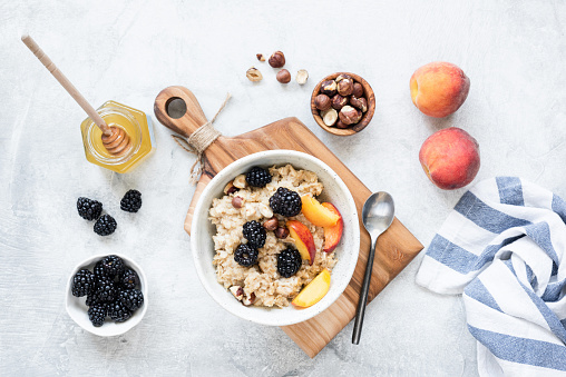 Oatmeal with fruits, nuts and honey. Healthy breakfast porridge. Clean eating concept