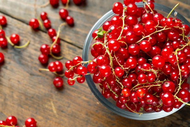 istock Red currant on brown wooden table. 1157805032
