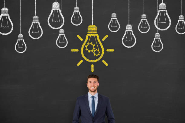 istock Idea solution concepts with light bulbs over business person head on a chalkboard background 1157806236