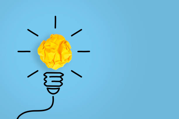 istock Idea Concepts Light Bulb Crumpled Yellow Paper on Blue Background 1157806339