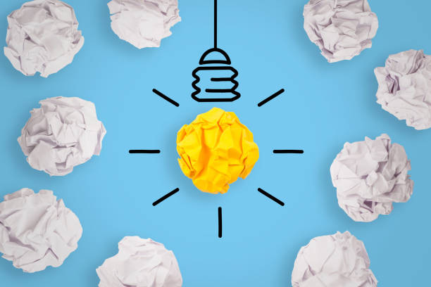 istock New Idea Concepts Light Bulb Crumpled Yellow Paper on Blue Background 1157806649