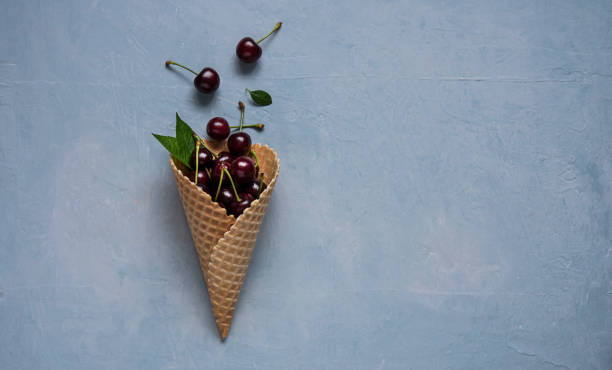 istock fresh redcherry berry in  waffle cone  on blue background  top view 1157816844