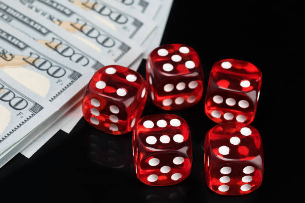 istock five red dice for gambling and hundred dollar bills on a black background 1157816866