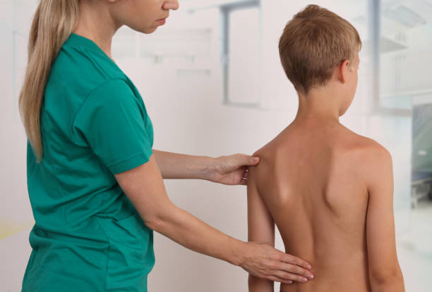 istock Child having chiropractic back adjustment. Osteopathy, Physiotherapy, Kinesiology. Bad posture correction 1157819687