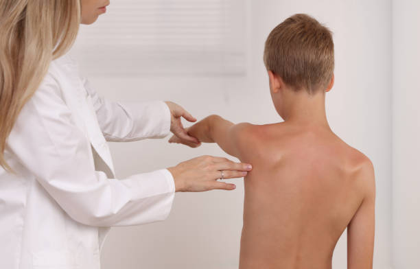 istock Child having chiropractic back adjustment. Osteopathy, Physiotherapy, Kinesiology. Bad posture correction 1157819816
