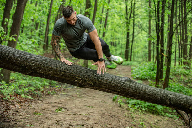 istock Flexible and Strong Mid Adult Jumping Over Tree Trunk 1157822478