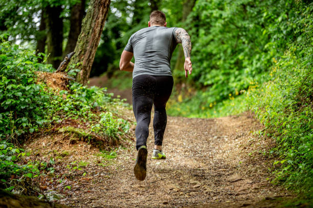 istock Determined Mid Adult Jogging in the Forest 1157822484
