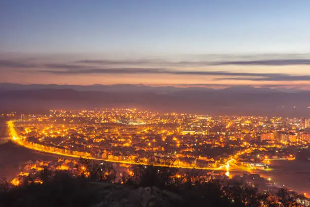Photo of Panoramic view of city lights and Pirot cityscape during late blue hour