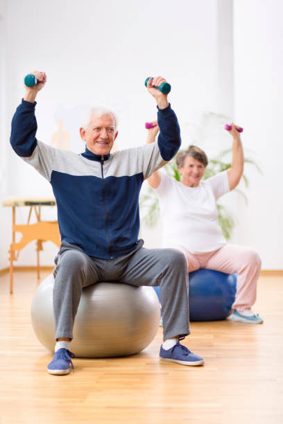 istock Two elderly patients exercising with weights in rehabilitation center 1157822568