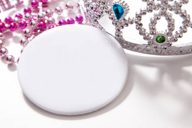 blank white button with jewelred princess tiara and beads empty white button with space with princess tiara and plastic beads princess crown tiara prom stock pictures, royalty-free photos & images