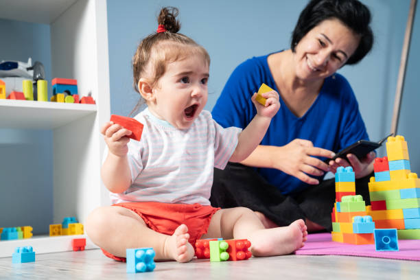 teléfono móvil adicta madre y niña - playing playful baby contemporary fotografías e imágenes de stock