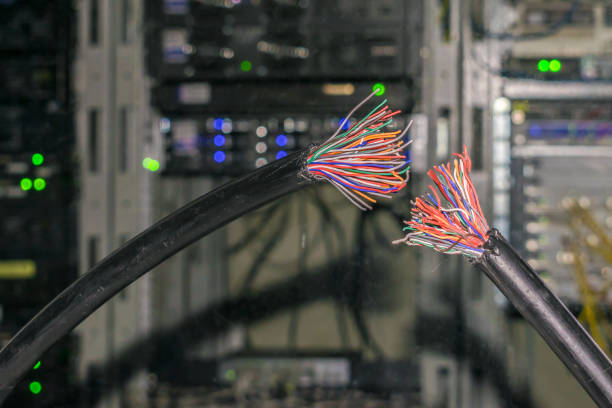 istock Two broken pieces of telecommunication wire. There is a damaged telephone Internet cable in the server room of the data center. The problem is on the technical node. 1157824637
