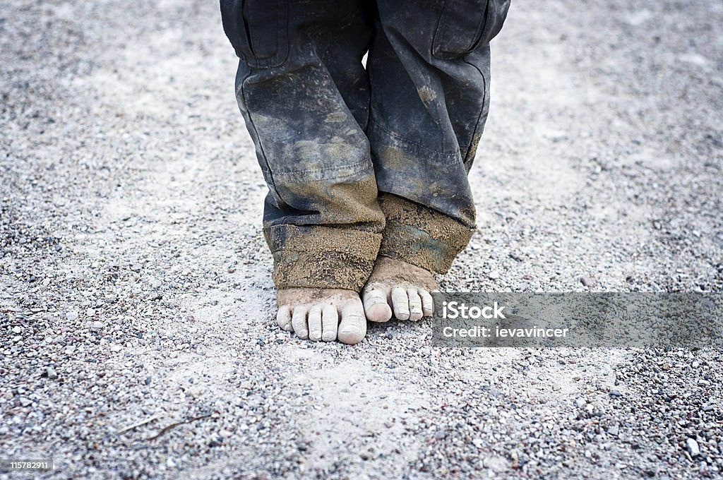 child's dirty feet dirty and bare child's feet on gravel. Poverty concept Child Stock Photo