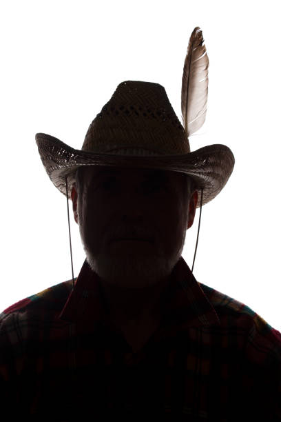 istock Old man in cowboy hat, front view - dark close-up silhouette 1157829937