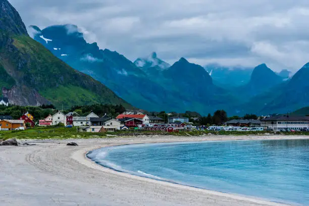 Rambergstranda beach in Lofoten  archipelago, Ramberg village and mountains covered with clouds are at background. Nordland, Northern Norway.