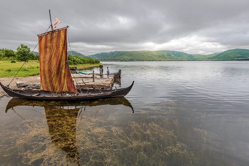 Lofotr, Norway - August 2, 2017  Reconstructed Viking ships in the border of Innerpollen salty lake in Vestvagoy island of Lofoten archipelago. The area is a part of Lofotr Historical museum. Nordland, Northern Norway.