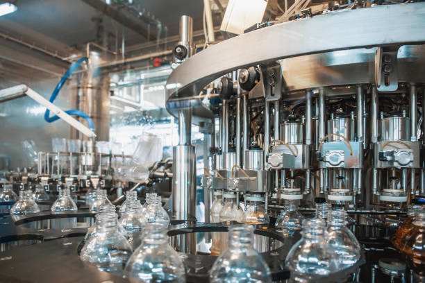 istock New empty clean PET plastic bottles inside industrial machine conveyor line or belt preparing for filling with beverage. Water and juice bottling plant 1157835644