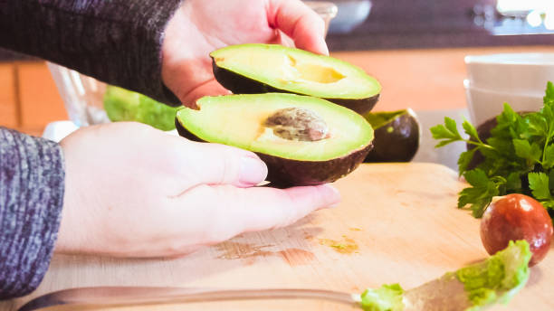 istock Slicing organic avocado on wood cutting board. 1157837107
