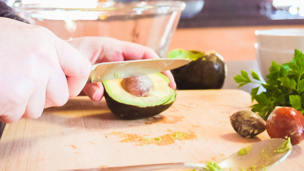 istock Slicing organic avocado on wood cutting board. 1157837259