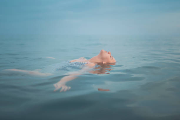 Young woman floating in sea, eyes closed