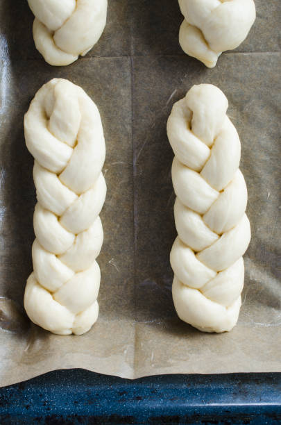istock Preparation process - raw unbaked buns. Yeast dough buns on baking paper, close-up. 1157838844