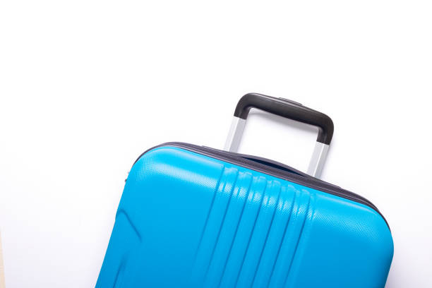 istock Blue suitcase on white background Creative Summer holidays, vacation, travel concept Banner 1157839538