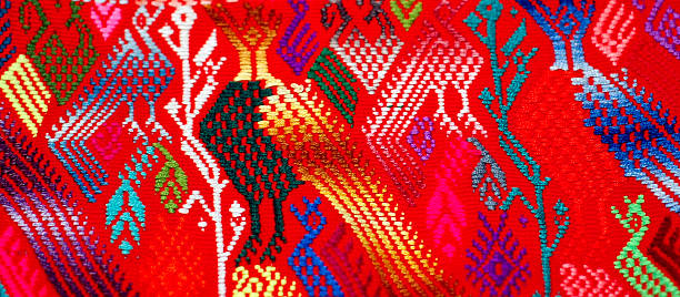 Corn bird abstract detail Guatemalan textile Handwoven on a traditional backstrap loom, the Huipil, cotton shirt, is the most important Mayan womens clothing item and an important part of Mayan identity. The design varies from village to village. This weaving incorporates a corn design with Quetzal birds. Most huipil designs are found in Guatemala some in southern Mexico. puerto quetzal guatemala stock pictures, royalty-free photos & images