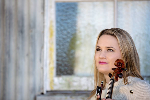 istock Female Musician Posing With Vintage Violin 1157845508