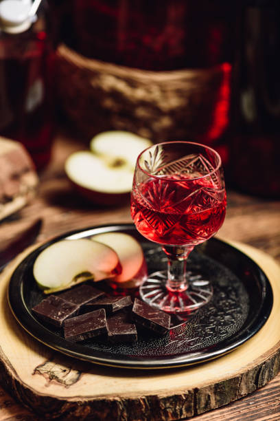 Homemade red currant nalewka and chocolate with apple Homemade red currant nalewka and chocolate with sliced apple on metal tray nalewka stock pictures, royalty-free photos & images