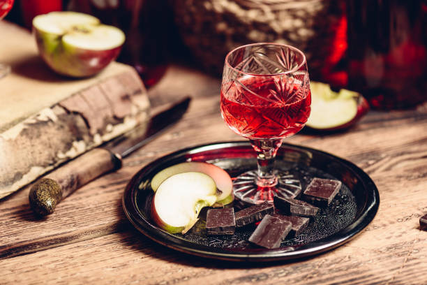 Homemade red currant nalewka and chocolate with apple Homemade red currant nalewka and chocolate with sliced apple on metal tray nalewka stock pictures, royalty-free photos & images