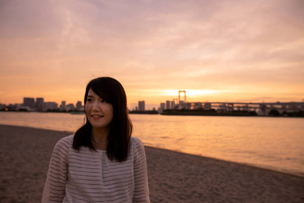 Young woman walking on beach at sunset time