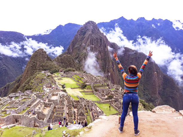 jeune femme avec les bras levés sur le fond de machu picchu. - footpath field nature contemplation photos et images de collection