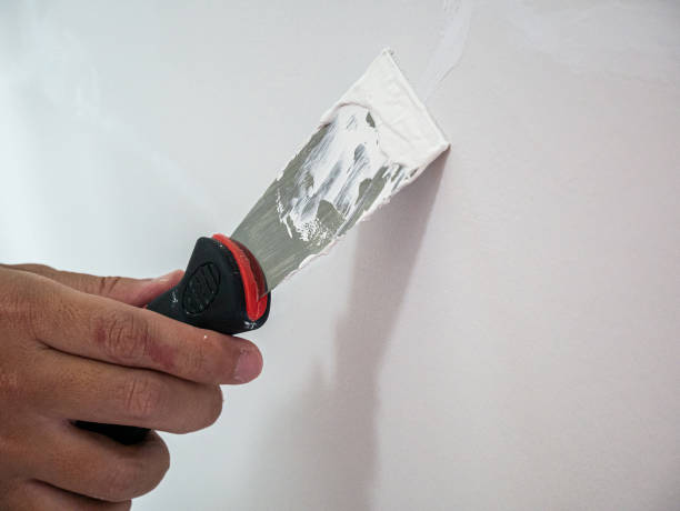 istock Plasterer hand repair crack white wall 1157859493