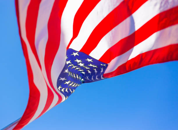 istock US Flag Blowing Upside-Down Against Blue Sky Background; Copy Space 1157859548