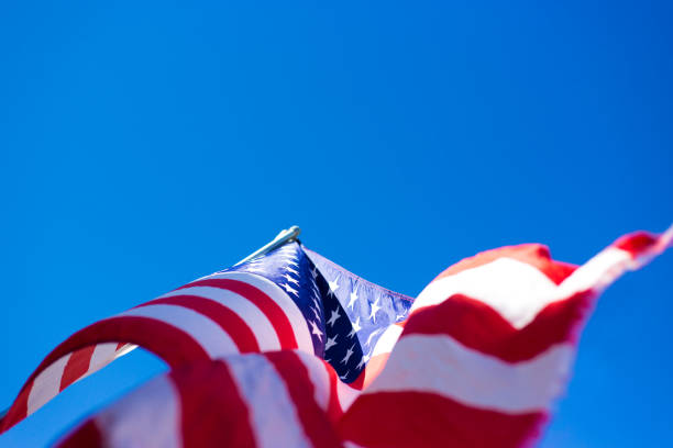 istock US Flag Blowing Wildly Against Blue Sky Background; Copy Space 1157859581