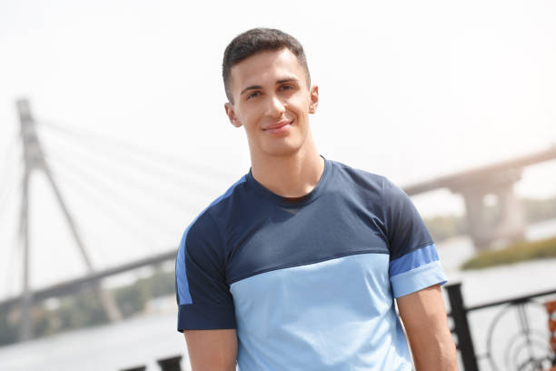 istock Healthy Lifestyle. Young man standing outdoors looking camera confident close-up blurred background 1157859861