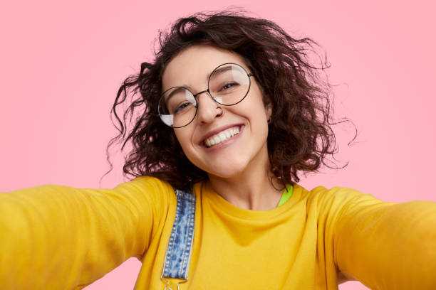 istock Cheerful young woman taking selfie 1157859974