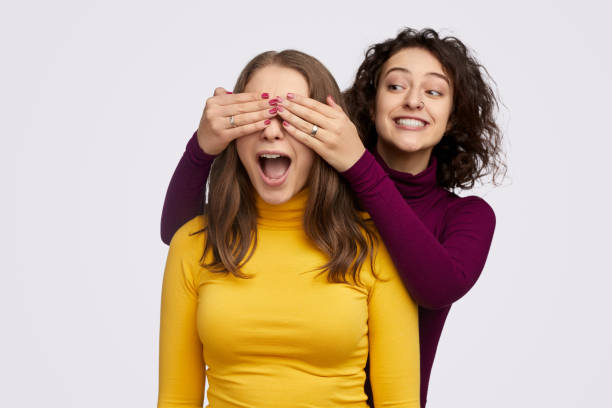 istock Cheerful female making surprise for best friend 1157859983
