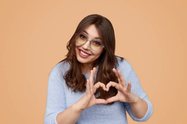 istock Happy female gesturing heart 1157860003