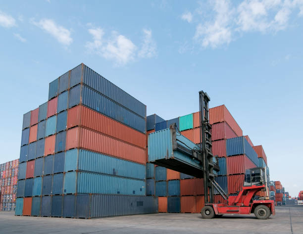 istock Forklift handling container box loading to truck in shipping yard with cargo container background, Logistic industrial concept. 1157861629