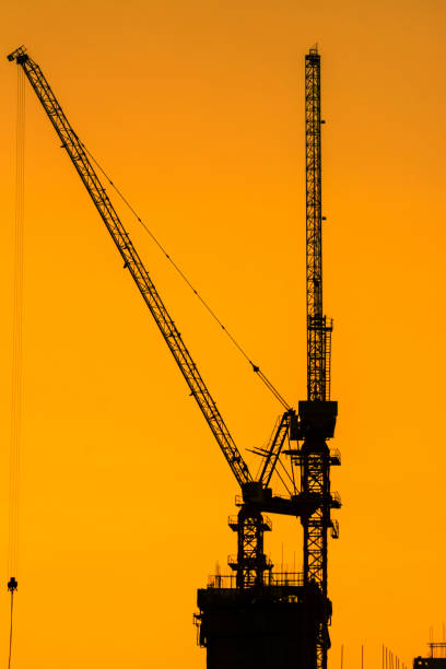 istock The silhouette of a large construction crane . 1157865994
